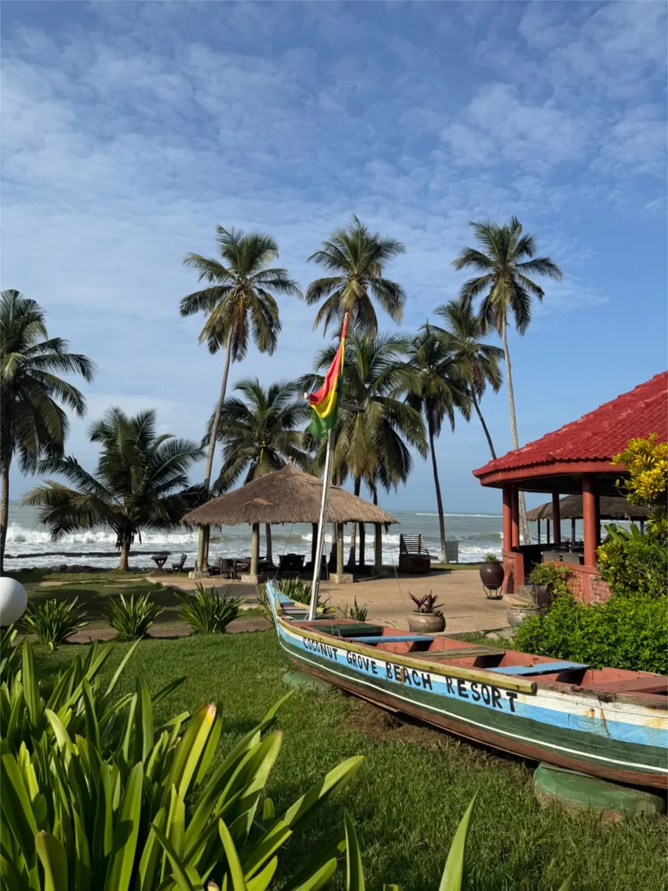 Palm trees and a branded Coconut Grove Beach Resort boat beside the ocean