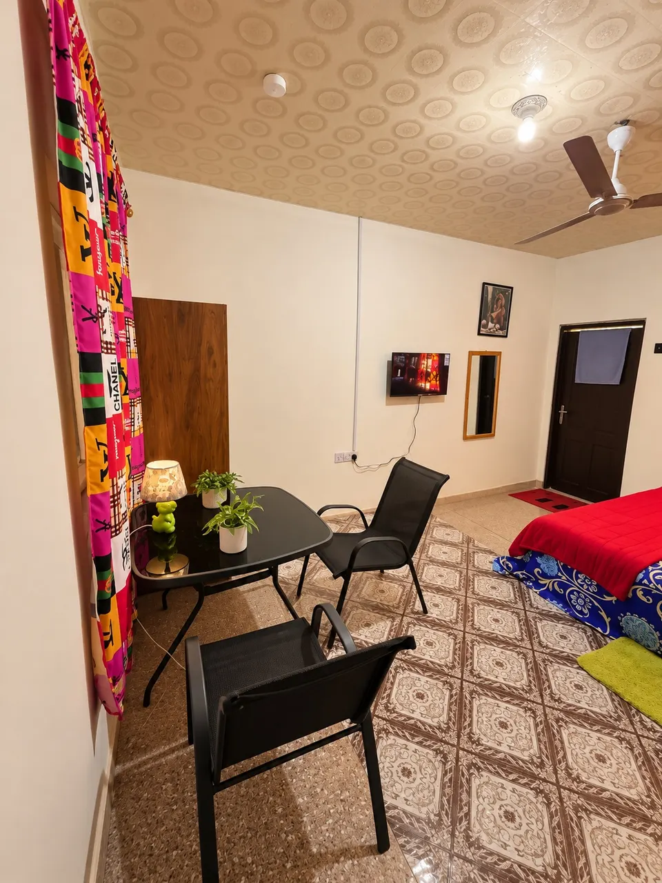 Room 1 at JaneChill Guest House — TV, table and partial bed